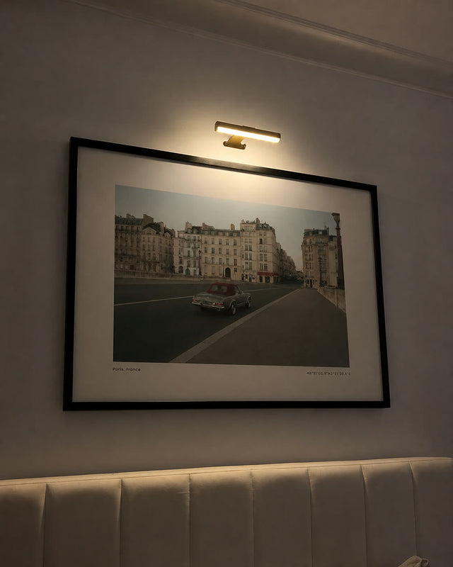 Sur le Pont above a bed under a picture light at night