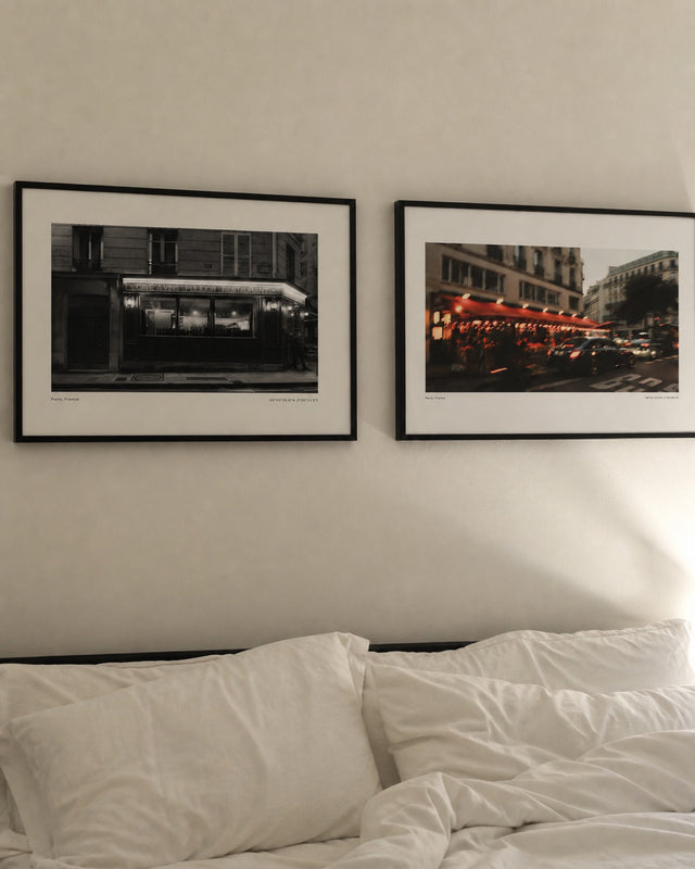 Two framed Paris prints above a bed - When the Clock Hits 10 and After Afterworks