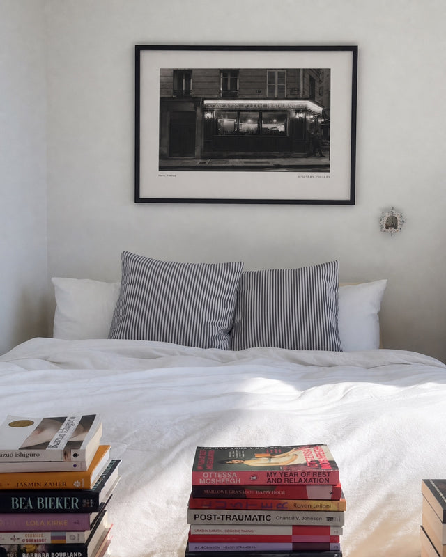 When the Clock Hits 10 print above a bed with books