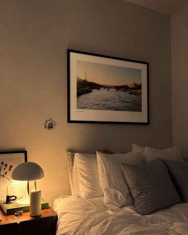 Paname print at night beside a bedside lamp
